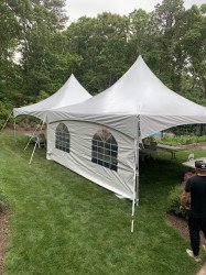 white tent with sides setup in a backyard